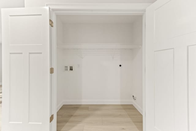 clothes washing area featuring hookup for a washing machine, light hardwood / wood-style floors, and electric dryer hookup