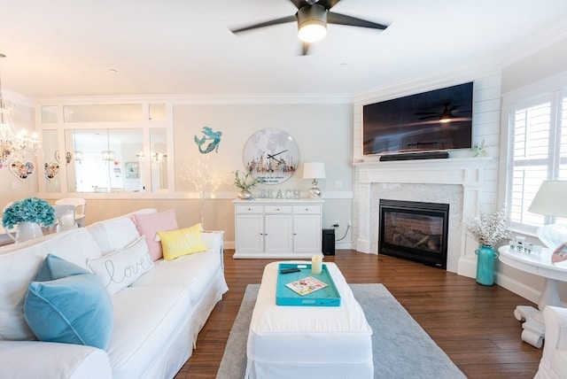 living room featuring ceiling fan with notable chandelier, dark hardwood / wood-style floors, and crown molding