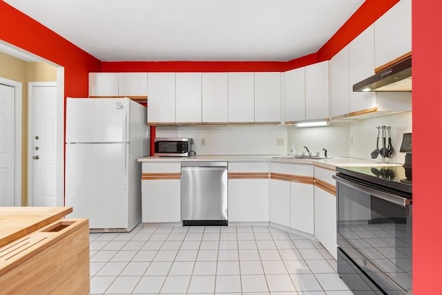 kitchen featuring stainless steel appliances, under cabinet range hood, light countertops, and white cabinetry