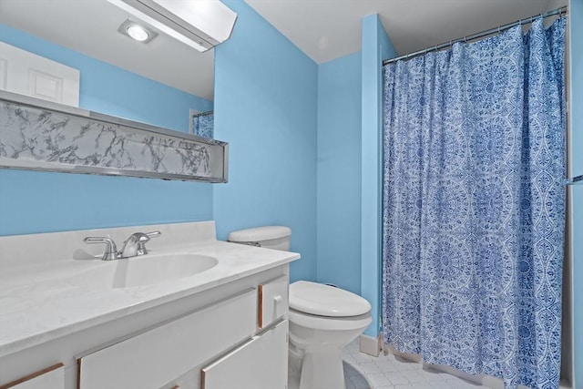 bathroom with tile patterned floors, toilet, vanity, and curtained shower