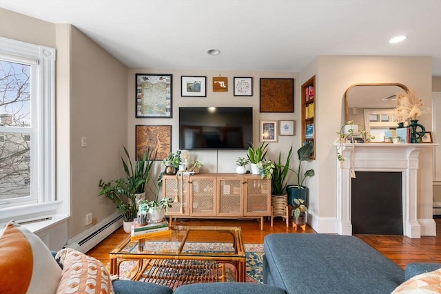 living area featuring baseboards, wood finished floors, a fireplace, a baseboard heating unit, and recessed lighting