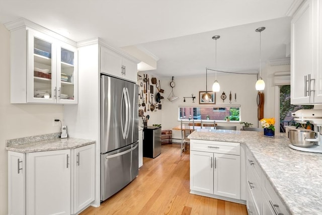 kitchen with freestanding refrigerator, white cabinets, light wood-type flooring, and glass insert cabinets