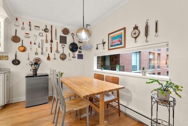 dining room with crown molding, light wood-type flooring, and baseboards
