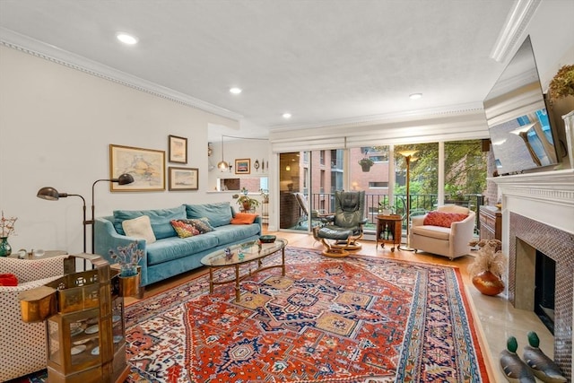 living area with a fireplace, ornamental molding, and recessed lighting