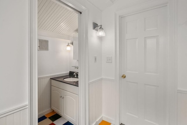 bathroom with a wainscoted wall and vanity