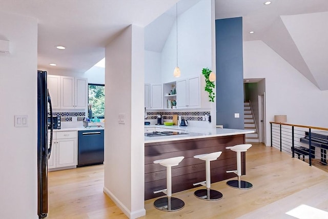 32 Garvey Rd, Framingham, MA 01701 - kitchen featuring dishwashing machine, light wood-style flooring, white cabinetry, decorative backsplash, and freestanding refrigerator