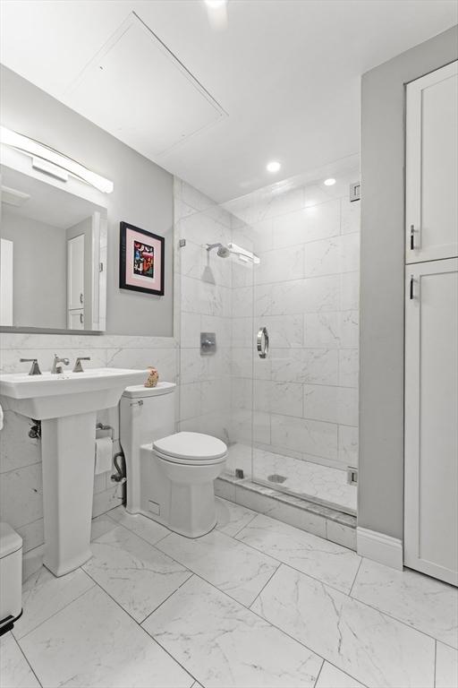 265 Beacon St Unit 5, Boston, MA 02116 - bathroom with marble look tiles, toilet, a stall shower, tile walls, and recessed lighting