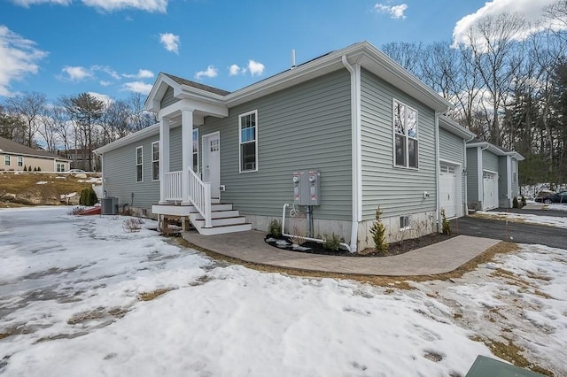 view of front of home with central air condition unit and aphalt driveway