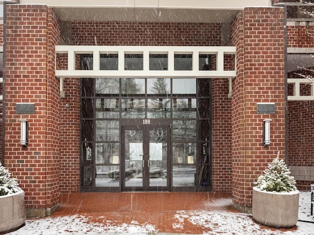 snow covered property entrance featuring french doors