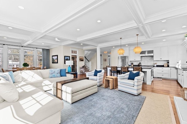 living area with beamed ceiling, light wood-style flooring, coffered ceiling, recessed lighting, and stairs