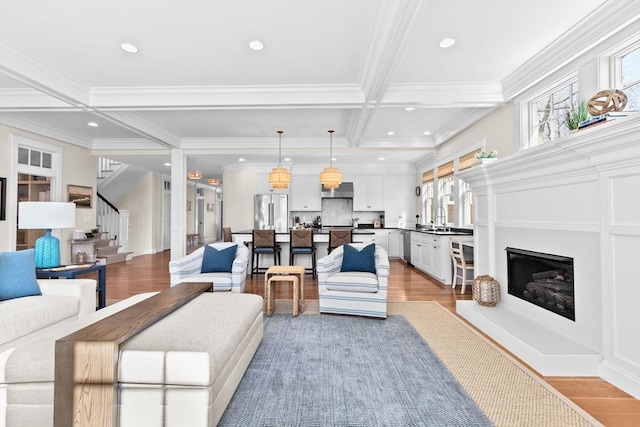 living room featuring beam ceiling, coffered ceiling, and light wood finished floors