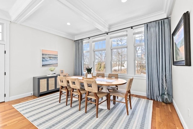 dining area featuring beamed ceiling, ornamental molding, and light wood-style flooring