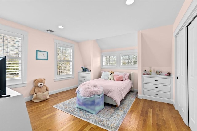 bedroom featuring baseboards, visible vents, recessed lighting, vaulted ceiling, and light wood-type flooring