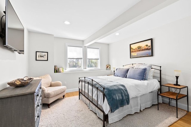 bedroom featuring beam ceiling, recessed lighting, light wood-type flooring, and baseboards