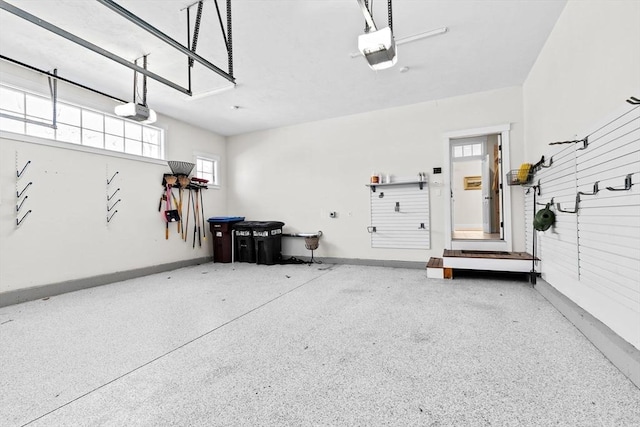 garage featuring a garage door opener and baseboards