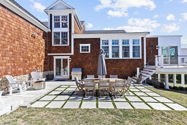 back of property with outdoor dining space and a patio