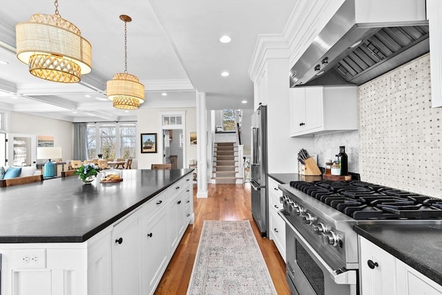 kitchen featuring white cabinetry, dark countertops, wall chimney exhaust hood, and premium appliances