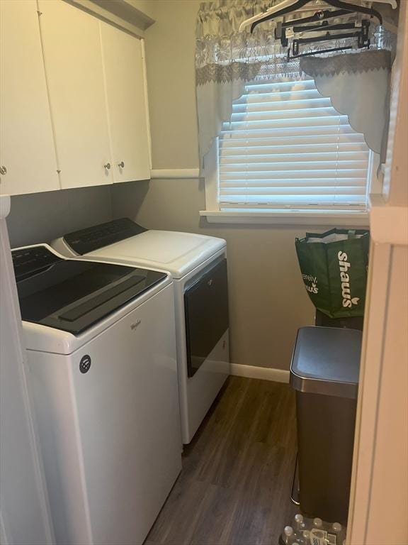 clothes washing area with cabinet space, baseboards, washer and clothes dryer, and dark wood-type flooring