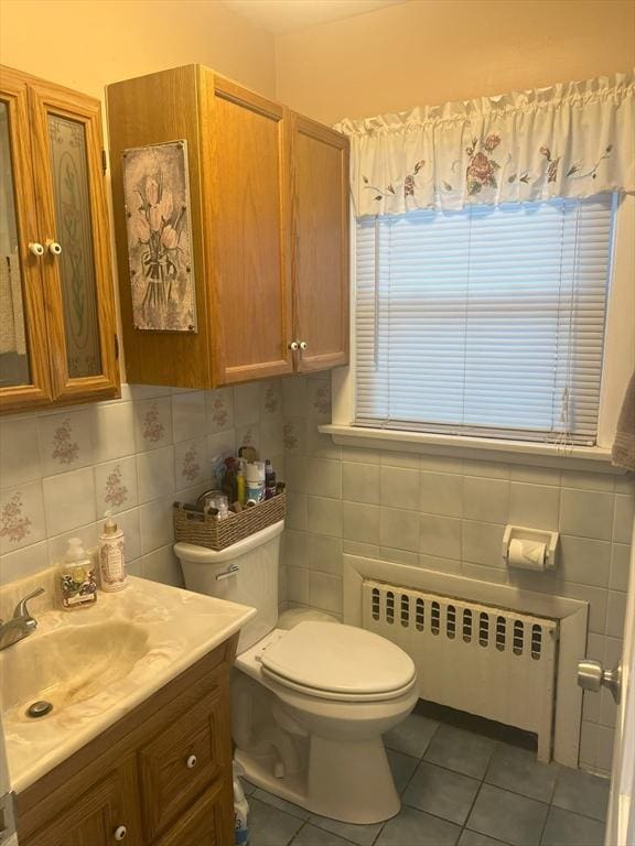 bathroom featuring vanity, radiator heating unit, tile patterned flooring, and tile walls