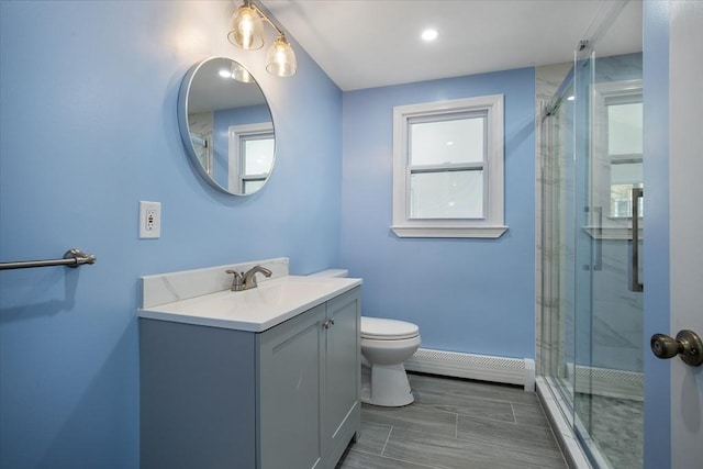 full bathroom with a baseboard heating unit, toilet, vanity, and a stall shower