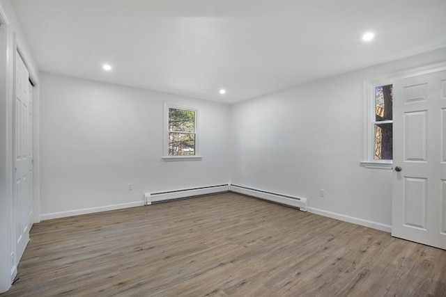 unfurnished bedroom with recessed lighting, wood finished floors, baseboards, and a baseboard radiator