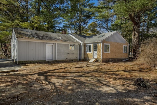 back of property with a chimney and entry steps