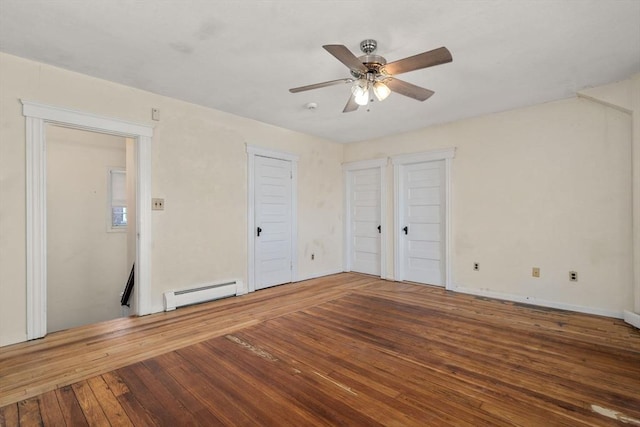 unfurnished bedroom featuring baseboard heating, multiple closets, a ceiling fan, and hardwood / wood-style flooring