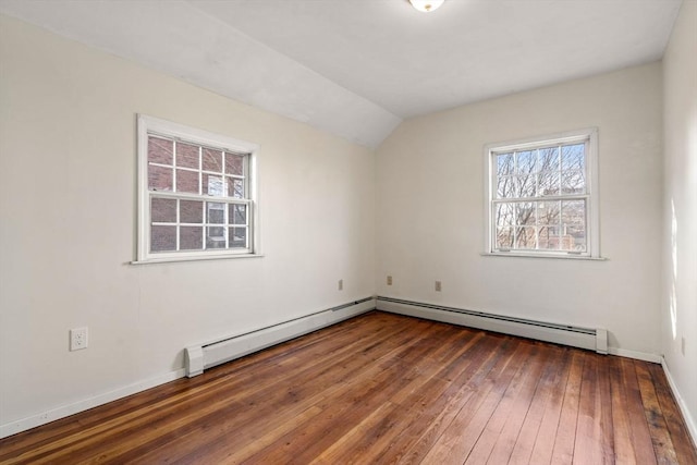 unfurnished room with a baseboard heating unit, baseboards, hardwood / wood-style floors, and vaulted ceiling