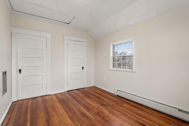 unfurnished bedroom featuring baseboards, a baseboard radiator, dark wood finished floors, attic access, and lofted ceiling