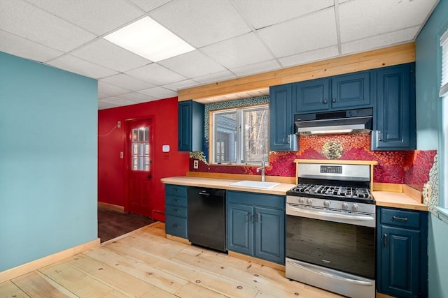 kitchen with blue cabinetry, under cabinet range hood, gas range, dishwasher, and a sink