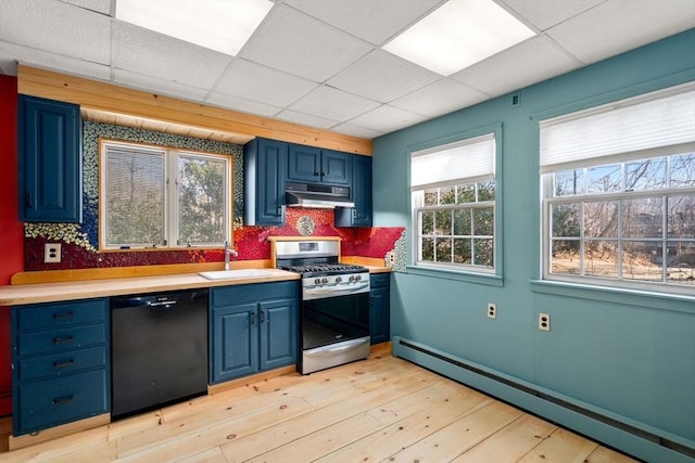 kitchen featuring blue cabinetry, under cabinet range hood, stainless steel range with gas stovetop, black dishwasher, and baseboard heating