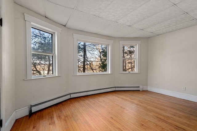 spare room with light wood-style flooring, baseboards, and a baseboard radiator