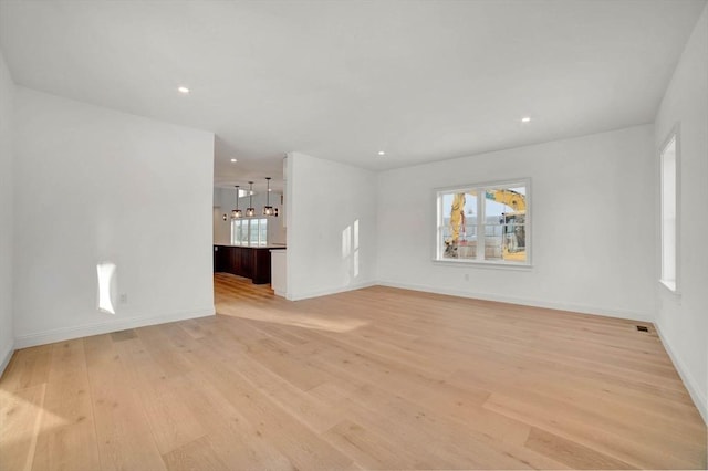 empty room featuring a wealth of natural light and light hardwood / wood-style flooring