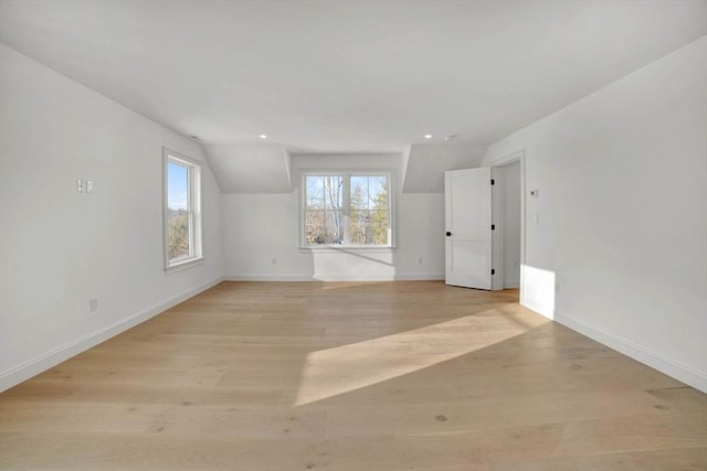 empty room with vaulted ceiling and light hardwood / wood-style flooring