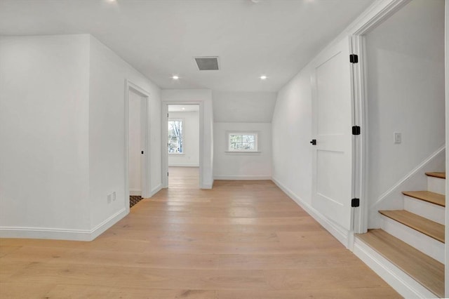 corridor with lofted ceiling and light hardwood / wood-style flooring