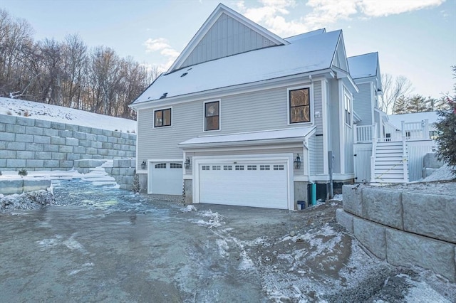 view of snow covered exterior with a garage