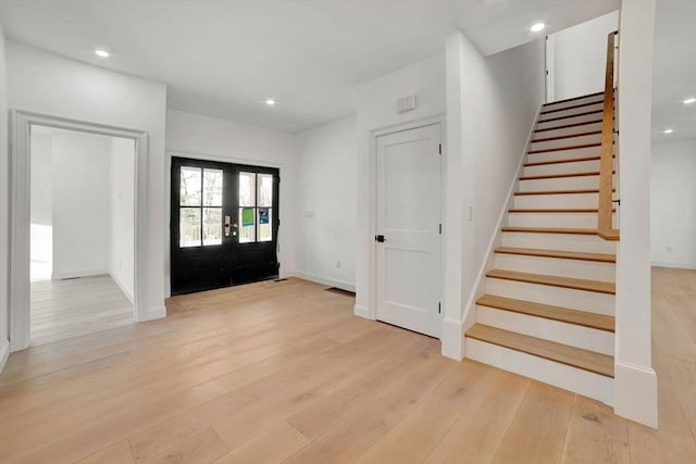 foyer with light hardwood / wood-style floors and french doors