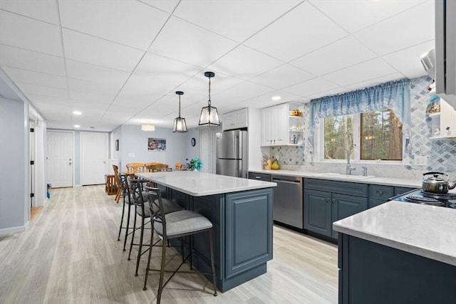 231 Manns Dr, Hanover, MA 02339 - kitchen with appliances with stainless steel finishes, a breakfast bar, light wood-style floors, and a sink