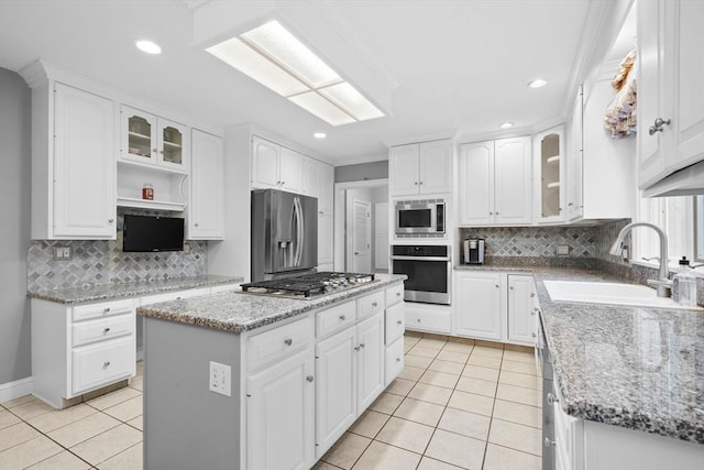 231 Manns Dr, Hanover, MA 02339 - kitchen featuring light tile patterned floors, tasteful backsplash, a sink, appliances with stainless steel finishes, and a center island