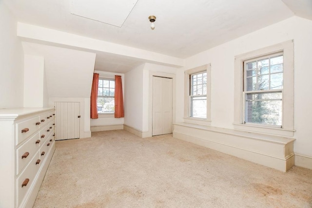 unfurnished bedroom featuring lofted ceiling, light colored carpet, and baseboards