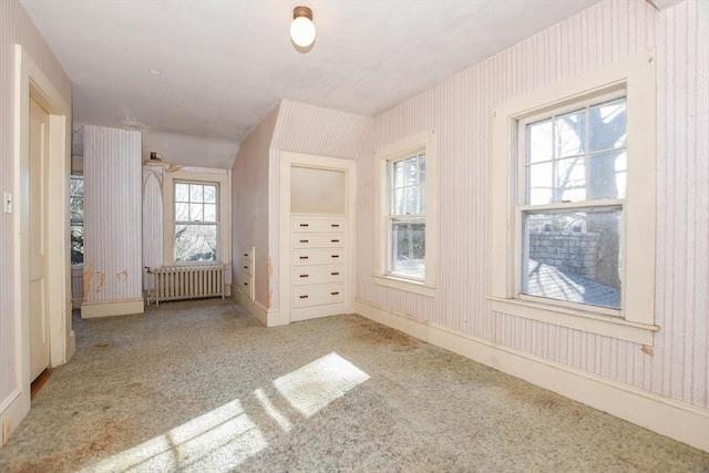 unfurnished bedroom with radiator, wallpapered walls, light carpet, and baseboards