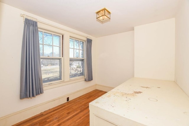 bedroom with baseboards and wood finished floors