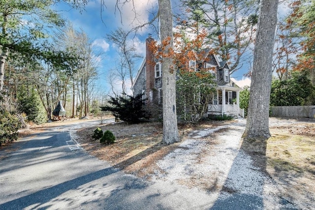 view of home's exterior featuring a porch and fence