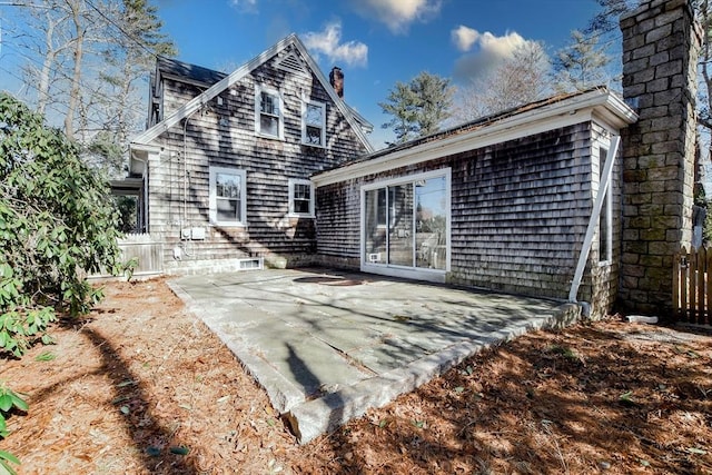 back of property featuring a chimney and a patio