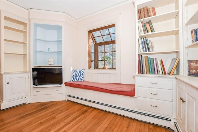 sitting room featuring built in shelves, a baseboard radiator, and wood finished floors