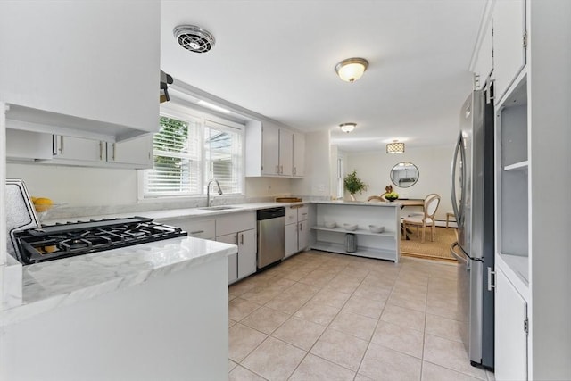 90 Woodland Rd, Malden, MA 02148 - kitchen with a sink, stainless steel appliances, light tile patterned floors, and a peninsula
