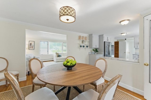 90 Woodland Rd, Malden, MA 02148 - dining area featuring light wood-style flooring, baseboards, baseboard heating, and crown molding
