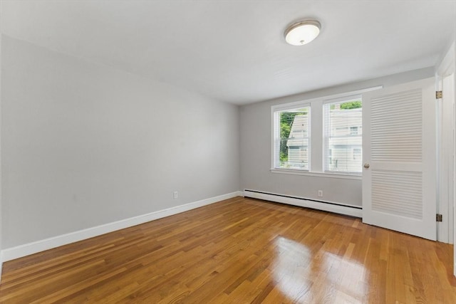 90 Woodland Rd, Malden, MA 02148 - spare room with a baseboard heating unit, wood finished floors, and baseboards