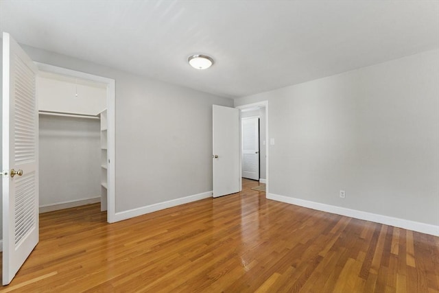 90 Woodland Rd, Malden, MA 02148 - unfurnished bedroom with baseboards, light wood-style flooring, and a walk in closet