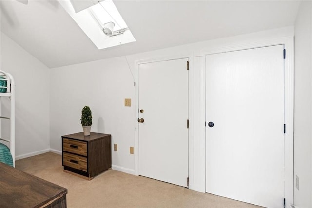 carpeted entrance foyer with lofted ceiling with skylight